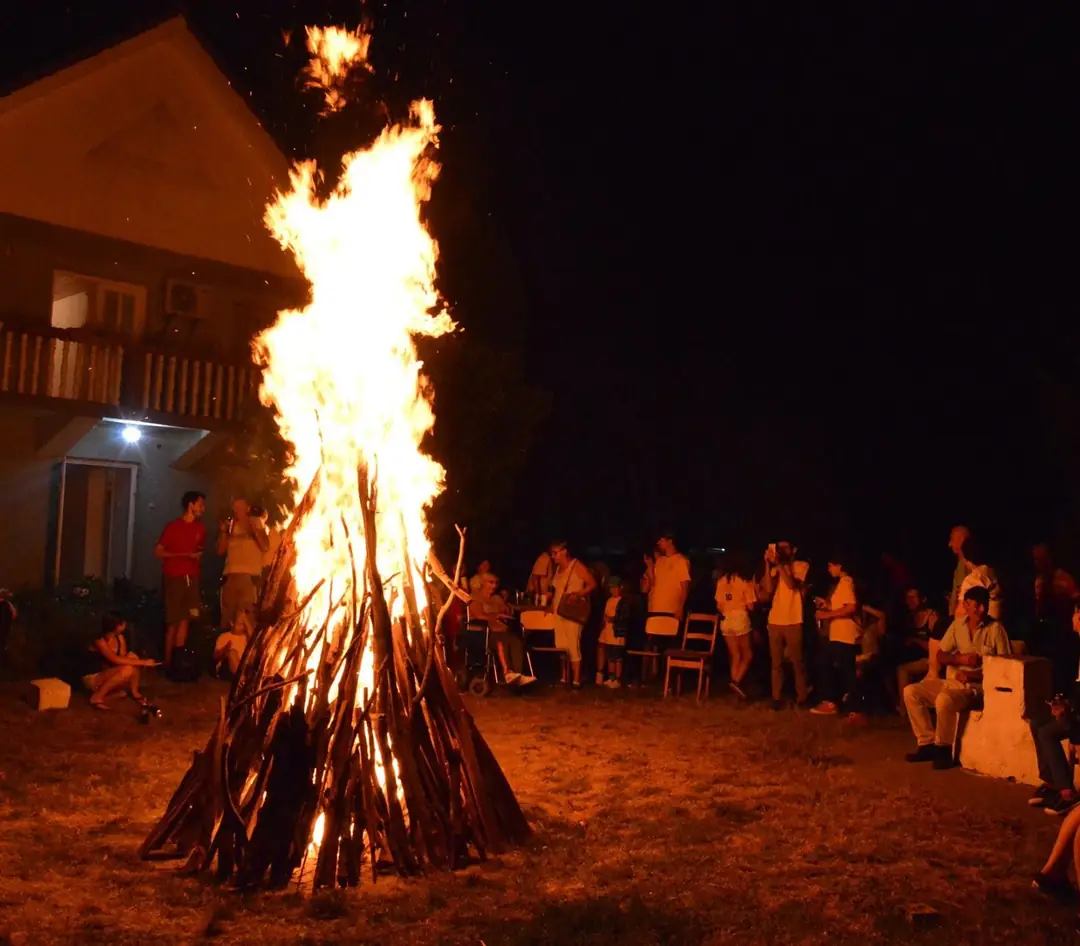 A campfire in the evening, with the participants gathered around it