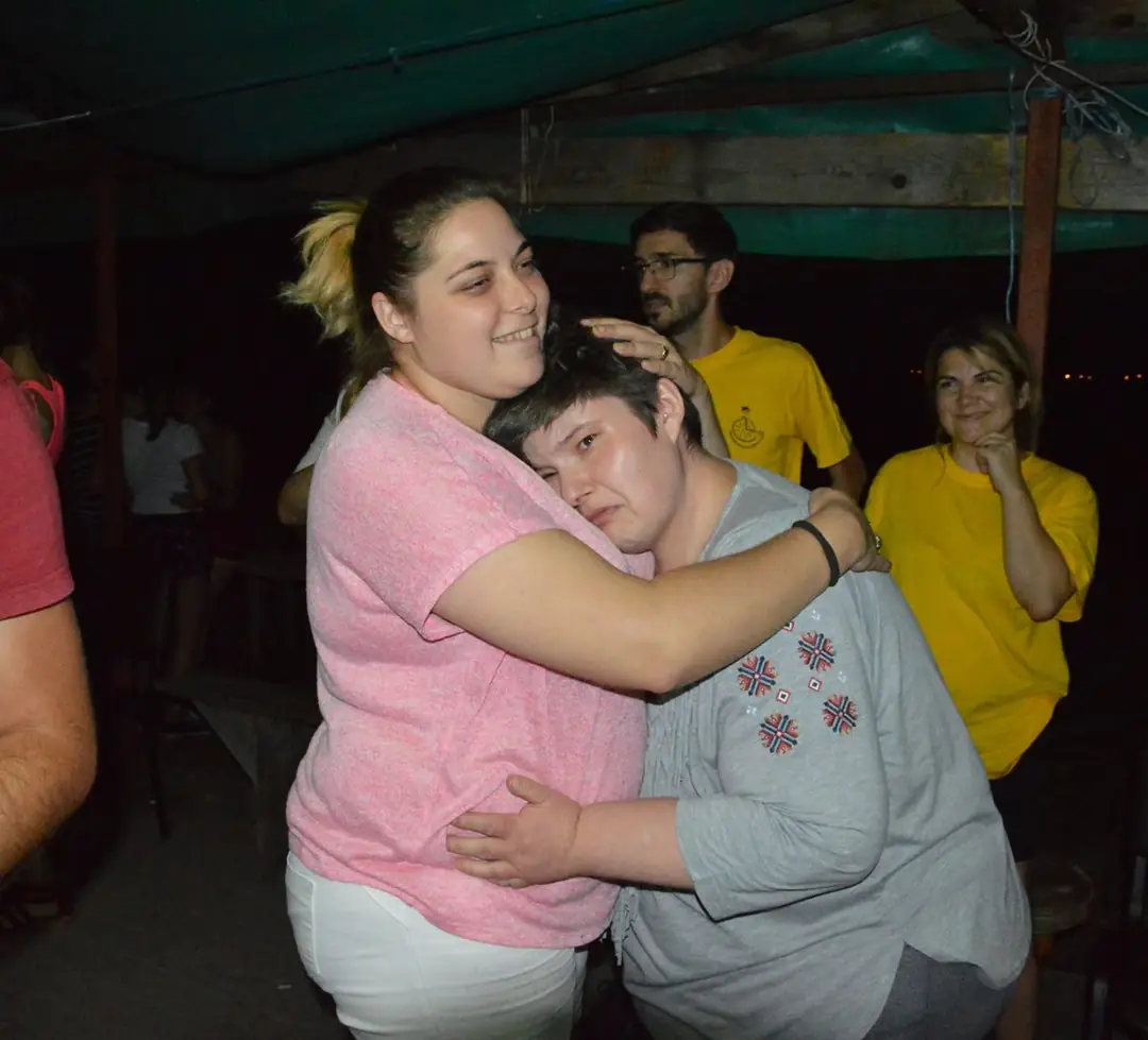 Two participants hugging during an evening at camp